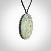 This piece is a contemporary disc pendant hand carved in New Zealand jade.